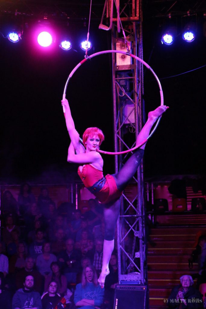 Woman during an amazing acrobatic aerial ring performance in a show of circus EigenArt