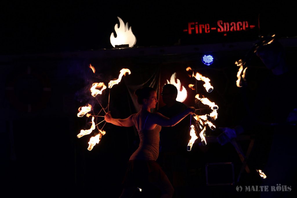 Fire performance with a fire fan on the fire space during the European Juggling Convention (EJC) 2016 in Almere, Netherlands